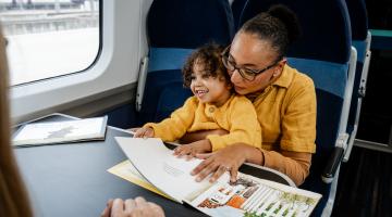 Rachel and Winnie reading a story book on a train